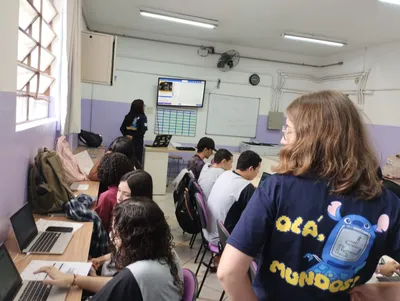 professores do Olá, Mundos! auxiliando alunos de uma das escolas lecionadas em 2025